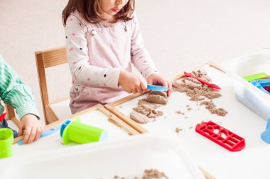 çocuk kumla oynuyor