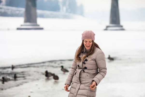 Ragazza che nutre anatre in inverno — Foto Stock