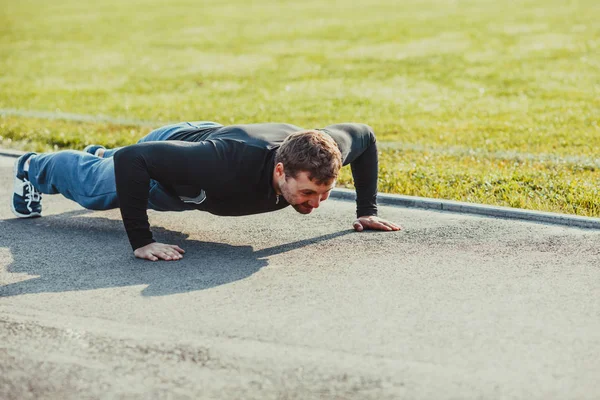 Entrenamiento con correas de suspensión En el gimnasio al aire libre,  fuerte entrenamiento de hombre temprano en la mañana en el parque, amanecer  o atardecer en el fondo del mar: fotografía de