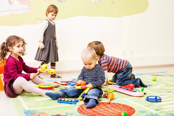 Drei Kinder spielen mit Spielzeug — Stockfoto