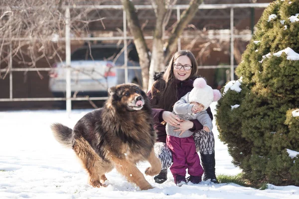 Mom with daughter and dog on winter walk