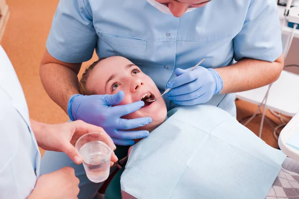 Стоматолог осматривает зубы — стоковое фото