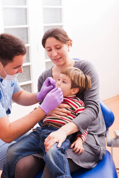 Mamá y su pequeño hijo visitando al dentista — Foto de Stock