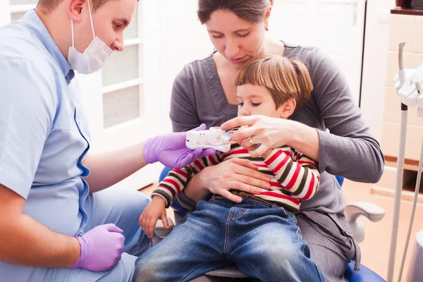 Mamá y su pequeño hijo visitando al dentista — Foto de Stock