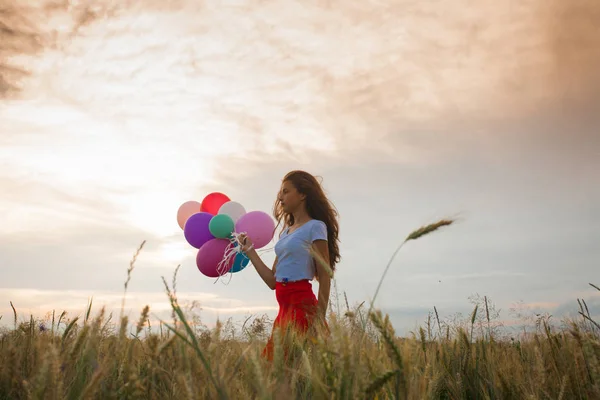 Girl with balloons in wheat field — Stock Photo, Image