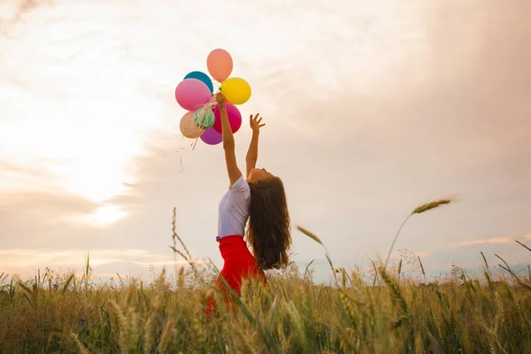 Chica con globos en el campo de trigo — Foto de Stock