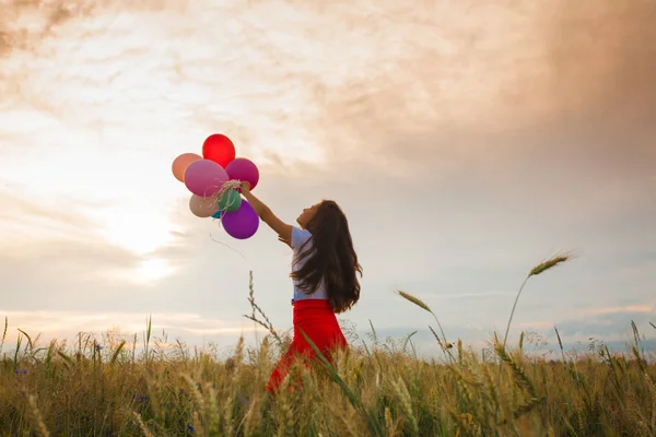 Chica con globos en el campo de trigo — Foto de Stock