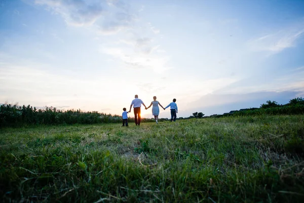 Счастливая семья на фоне заката — стоковое фото
