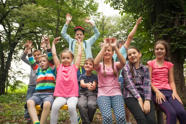 Grupo de niños en un banco del parque — Foto de Stock