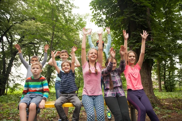 Çocukların bir parkta bankta grup — Stok fotoğraf
