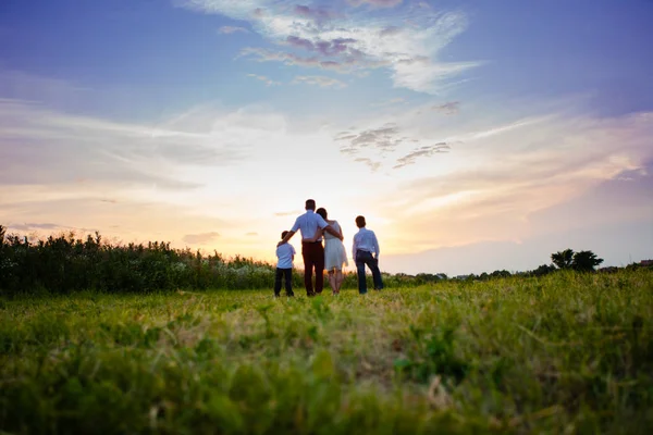 夕阳背景下的幸福家庭 — 图库照片
