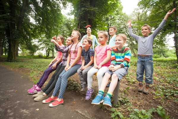 Grupa dzieci na ławce w parku — Zdjęcie stockowe