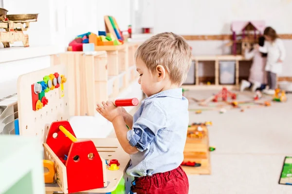 Garçon joue avec des jouets en bois — Photo