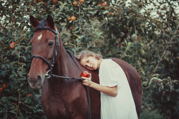 Una mujer alimenta a un caballo —  Fotos de Stock