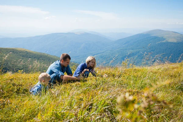 De familie smaakt wilde bessen — Stockfoto