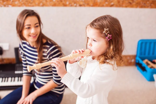 La petite fille à jouer sur la flûte — Photo