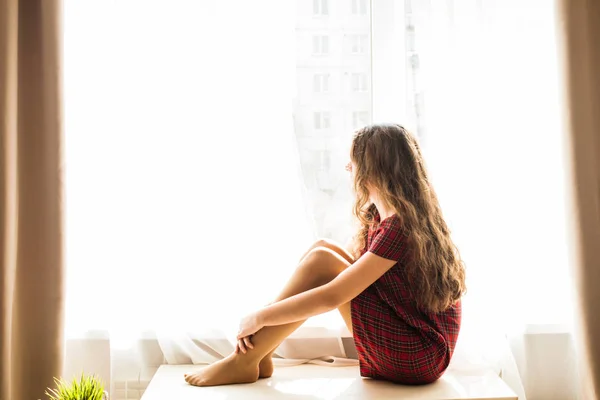 Schattige tiener meisje zit in de buurt van venster — Stockfoto