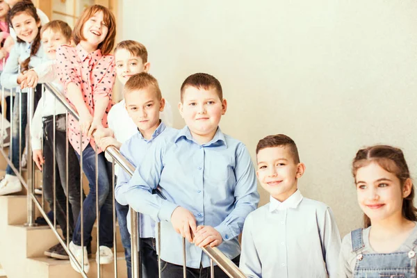 Alumnos de pie en las escaleras — Foto de Stock