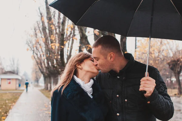 Jovem casal sob um guarda-chuva — Fotografia de Stock