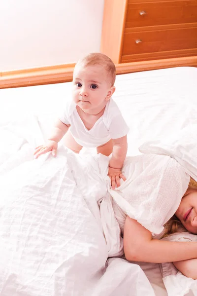 Baby weckt schläfrige Mutter auf — Stockfoto