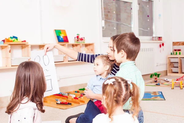 Leraar leert kinderen verschillende cijfers — Stockfoto