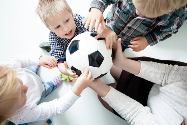 Children stretch to the ball