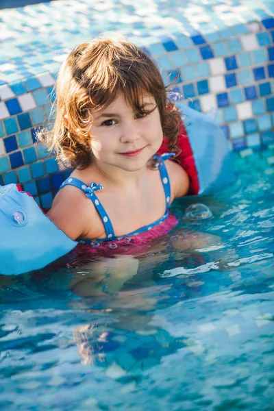Mädchen in Armbinden im Schwimmbad — Stockfoto