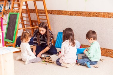 öğretmen çocuklarla oynuyor.