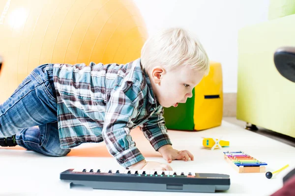 O menino aprende instrumentos musicais — Fotografia de Stock