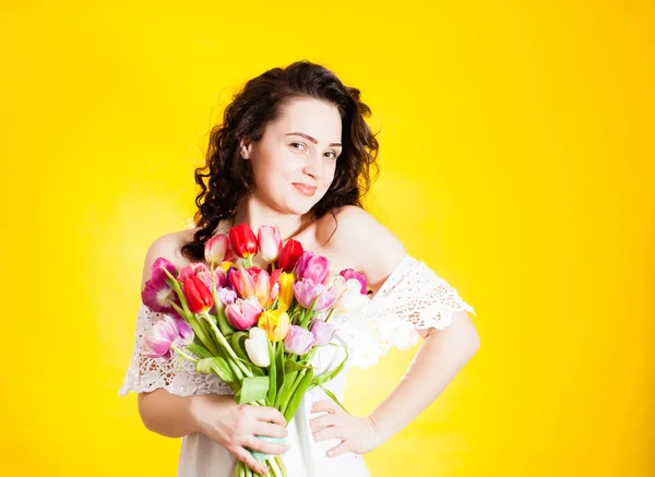Schöne Frau mit Tulpen in der Hand — Stockfoto