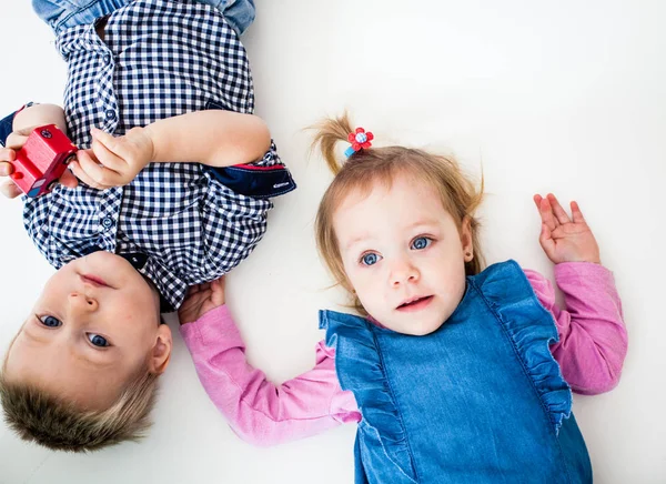 O menino e a menina deitados isolados — Fotografia de Stock