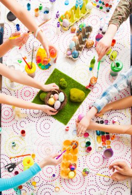 Top view table with Easter decoration and kids hands