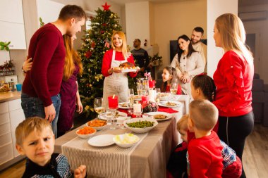 Group of friends gathered around table at Christmas