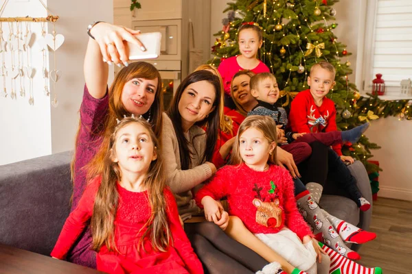 Matki i ich dzieci robią selfie na kanapie — Zdjęcie stockowe