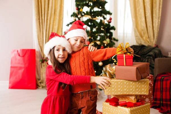 Szczęśliwy uśmiech dzieci z prezentów świątecznych w domu. — Zdjęcie stockowe