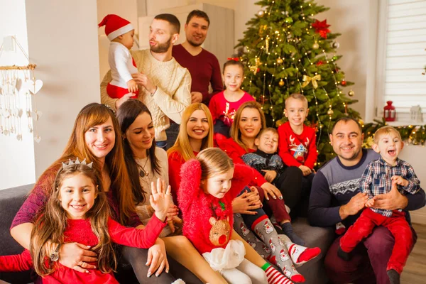 Grande famiglia posa sul divano vicino all'albero di Natale — Foto Stock