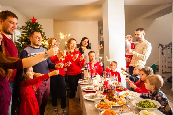 Happy family with sparklers having fun at dinner party at home. — Stockfoto