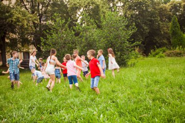 Kids playing funny games in a park in summer time