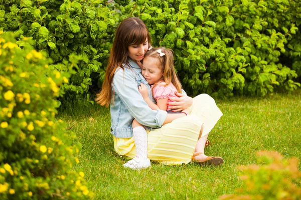 Lovely mother and child daughter in nature on green grass — 图库照片