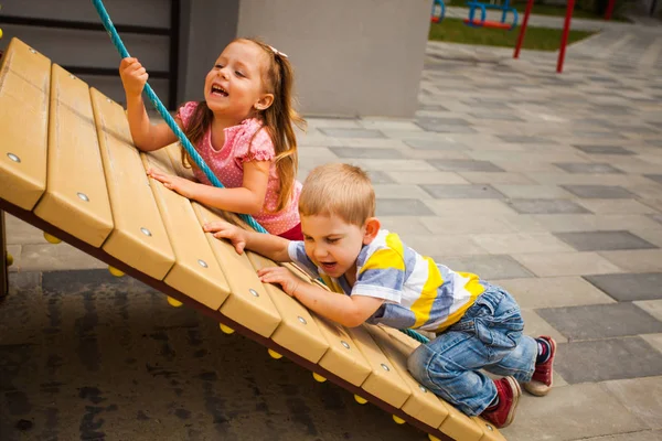 Crianças tentando escalar a corda no playground — Fotografia de Stock