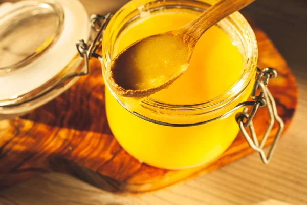 Wooden spoon with ghee - clarified butter in jar — Stok fotoğraf