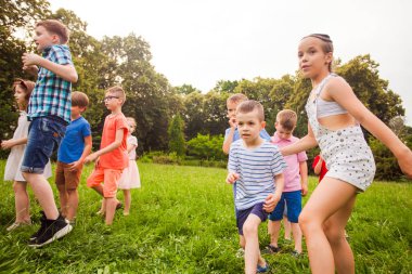 Kids playing funny games in a park in summer time