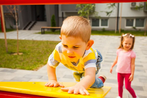 Niños jugando juntos en un moderno parque infantil al aire libre — Foto de Stock