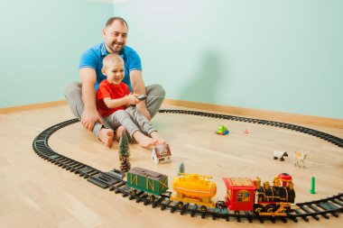 Mutlu baba, çocuk odasında bebekle oynuyor.