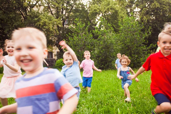 Велика група дітей, що біжать у парку — стокове фото
