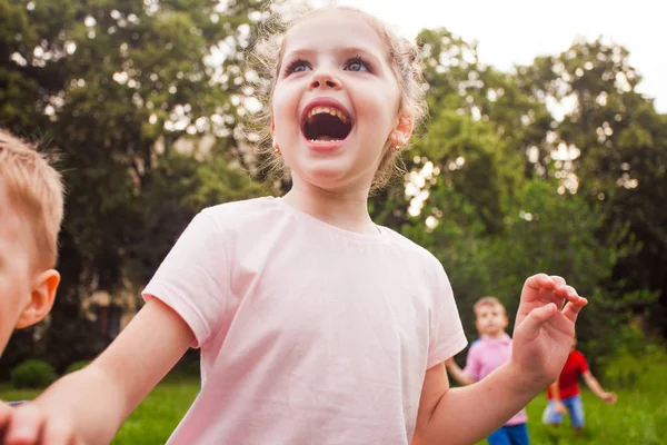 Glada barn leker på naturen på en barnkalas — Stockfoto