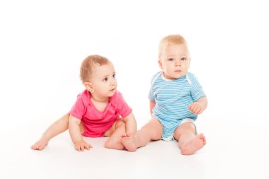 Lovely baby boy and baby girl are playing isolated over white background
