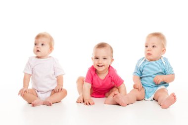 Cute babies sitting on white studio background