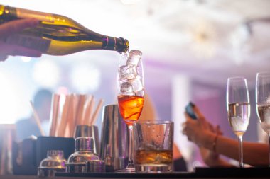 Bartender preparing aperol cocktail in a cocktail bar