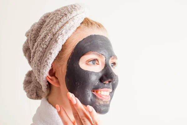 Szczęśliwa kobieta nakłada czarną maskę twarzy — Zdjęcie stockowe